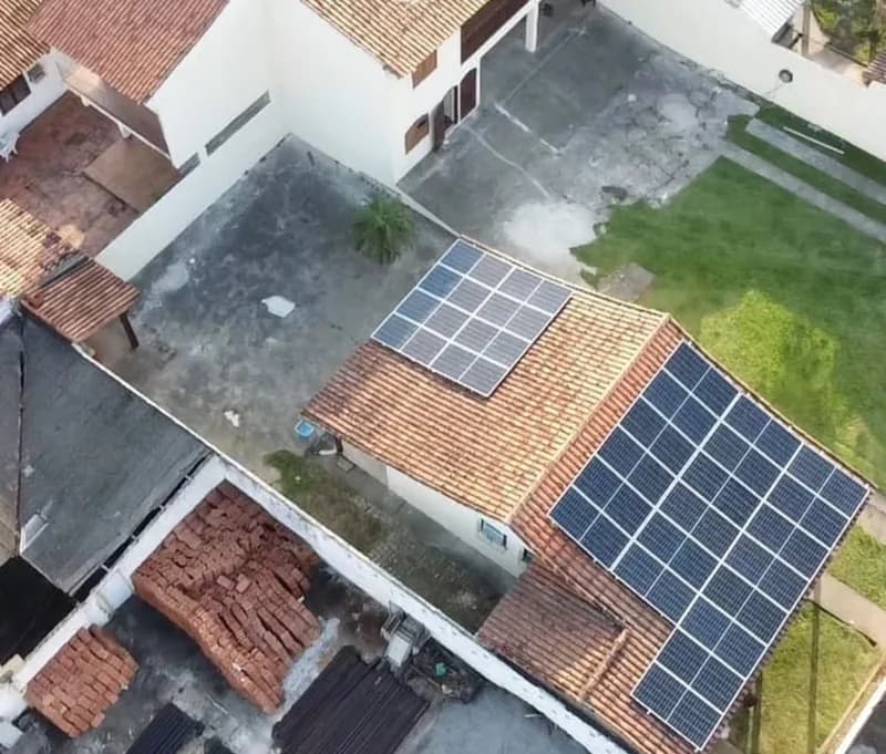 Vista aérea de residência em telhado colonial com dois conjuntos de painéis solares instalados